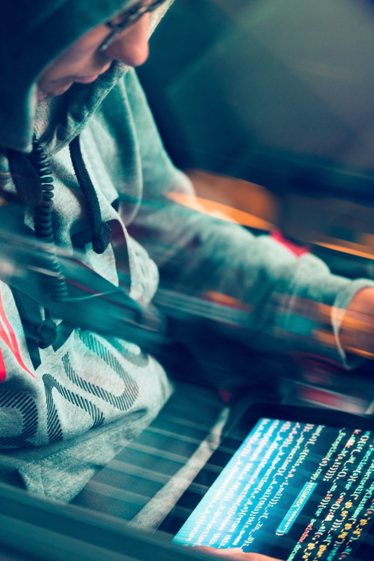 Hacker using computer, smartphone and coding to steal password and private data remotely from car
