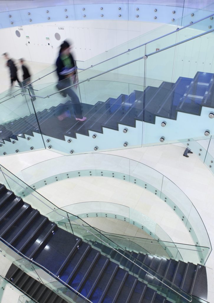 people inside a modern building (color toned image; motion blurr