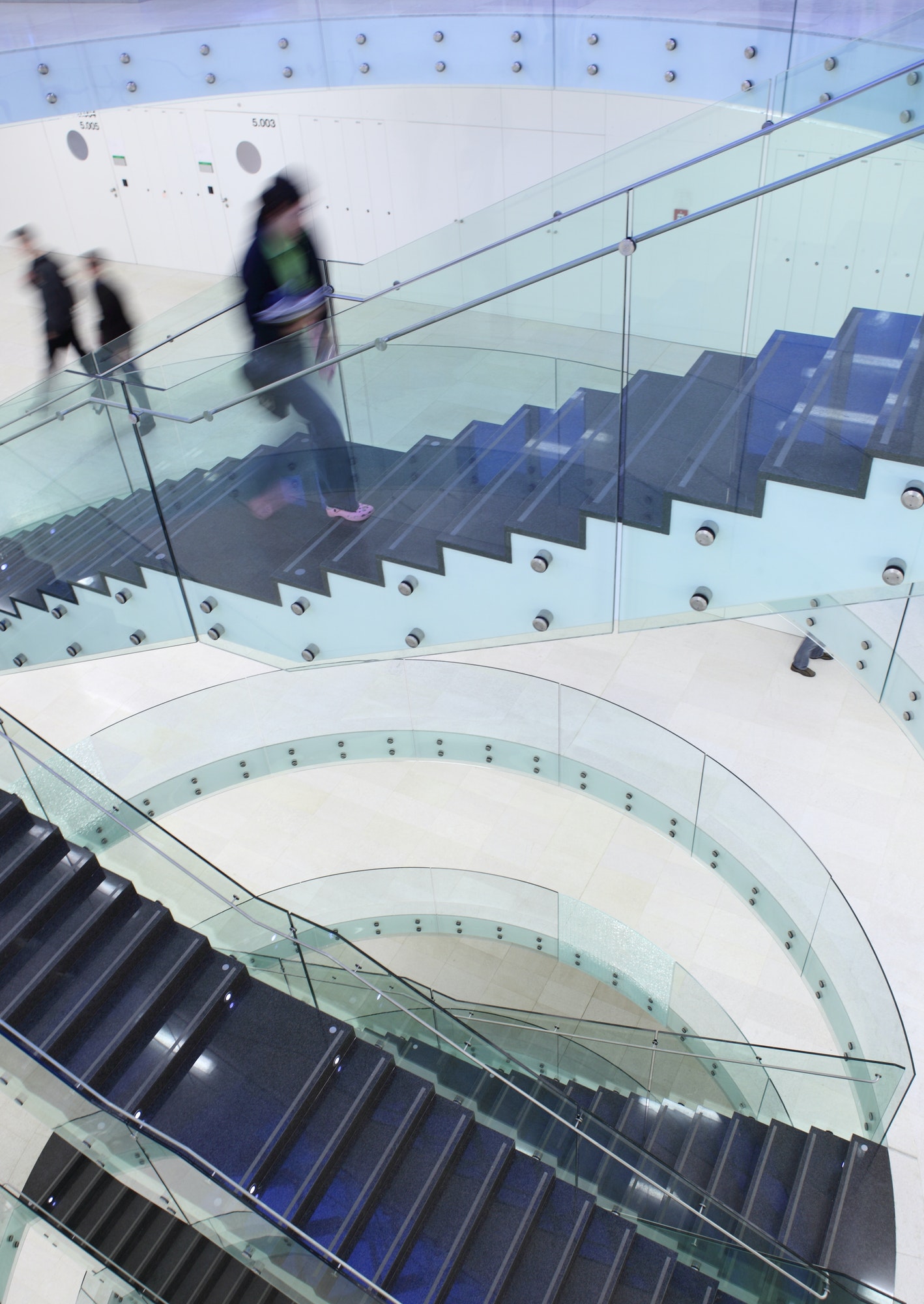 people inside a modern building (color toned image; motion blurr